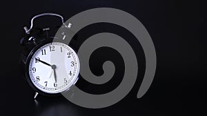 Close up image of old black vintage alarm clock. 10 minutes before six o `clock