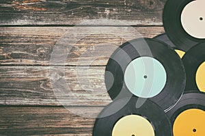 Close up image of old records over wooden table , image is retro filtered .