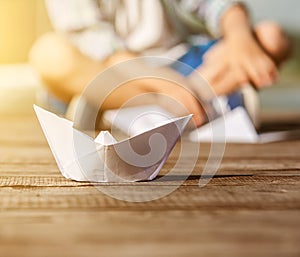 Close up image paper ship on the wooden pier