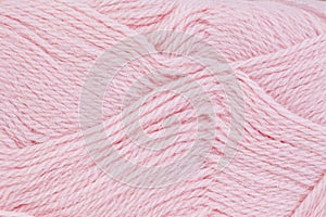 A close up image pink of wool yarn for knitting. Background