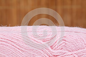 A close up image pink of wool yarn for knitting. Background