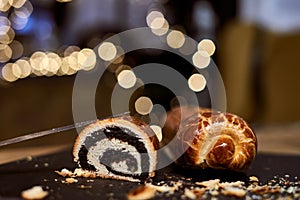 Close up image of poppy seed roll cake, traditional Christmas beigli on table at home, restaurant or patisserie