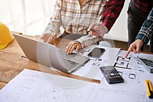 Close-up image of a professional engineer team are checking building plan on laptop