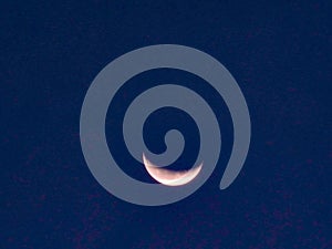 Close up image of quarter moon against the backdrop of day sky .