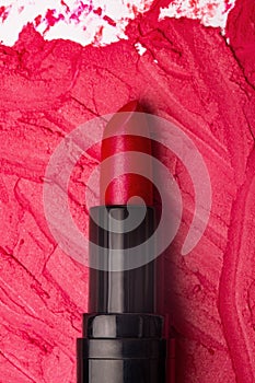 Close-up image of red lipstick on a smudged lipstick background