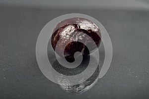 Close up of image of rotten red cherry fruit on reflective black