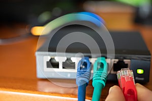 Close-up image of a router: the connections of the three red, green and blue ethernet cables are tested. Concept of cabling,