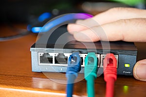 Close-up image of a router: the connections of the three red, green and blue ethernet cables are tested. Concept of cabling,