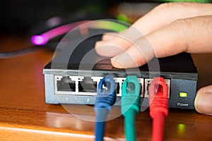 Close-up image of a router: the connections of the three red, green and blue ethernet cables are tested. Concept of cabling,