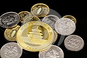 A close up image of Russian Federation coins with an American gold coin on a black background