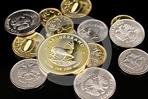 A close up image of Russian Federation coins with a gold South African Krugerrand on a black background