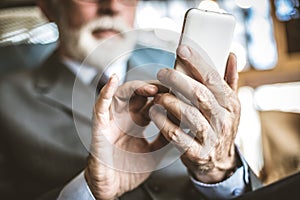 Close up image of senior businessman using mobile phone.