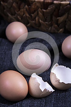 Close-up image of  several unbroken eggs next to a broken egg