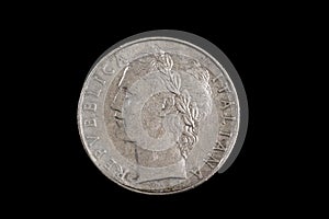 An old Italian lira coin shot against a black background