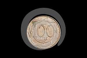 An old Italian lira coin shot against a black background