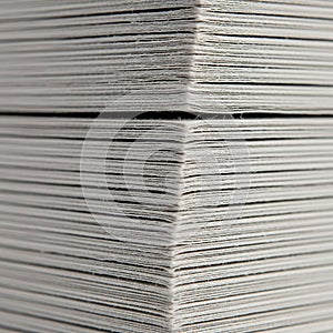 Close up view of a stack of white paper sheets arranged in parallel lines