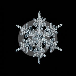 A close-up image of a snowflake displaying intricate geometric patterns. The