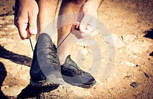 Close up image of sportsman tying shoes.