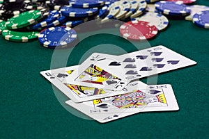 A close up image of stacked poker chips and a royal flush.