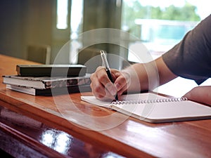 Close up image of student writing on a coffee mug on a coffee table