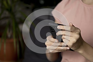 A close-up image of a teenage girl& x27;s hands using a smartphone at home in the living room, the concept of social