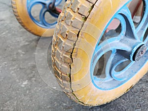 Close up image wheelbarrow tyre with cracked sidewall and worn rubber tread. Selective focus.