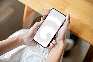 Close-up image of a white screen smartphone mockup in a woman's hands