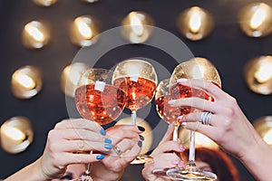 Close up image of woman hands with stylish manicure holding glasses with champagne , black and white style, party time