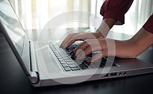 Close up image of woman hands typing on laptop computer keyboard ,  surfing the internet or online working . business and technolo
