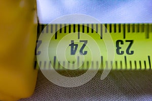 Close-up image of a yellow-colored roll meter in centimeters, you can also see the dashes that mark the millimeters.