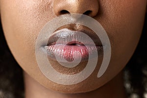 Close-up image of young african woman, female lips. Lip augmentation, care, permanent makeup, moisturizing products