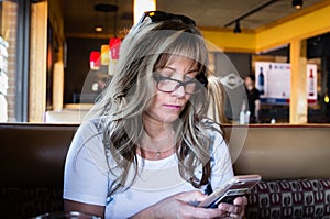 Close up image of young ash blonde woman on her cell phone