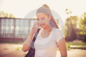 Close up image of young sport woman talking phone.