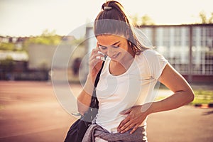 Close up image of young sport woman talking phone.