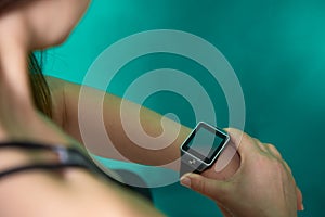 Close up image of young woman checking the time on smart watch device