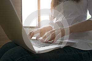 Close-up image of young woman hands typing and writing massages