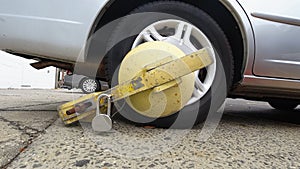 Close up of impounded car tire with yellow boot lock in New York City