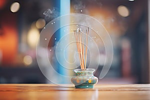 close-up of incense stick burning on a wooden holder