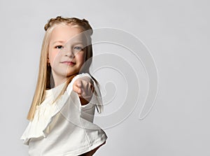 Close up of the index finger of a cute little girl pointing at you. White background.