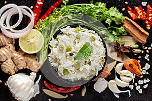 Close-up of Indian Basmati steamed Rice or matar Pea pulao or Pulav garnished with fresh green mint leaf in a black bowl