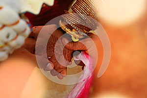 Close up of Indian bride and groom holding hands after the wedding ceremony,