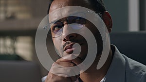 Close up Indian man in glasses Arabian businessman with laptop thinking holding chin pensive thoughtful employer think