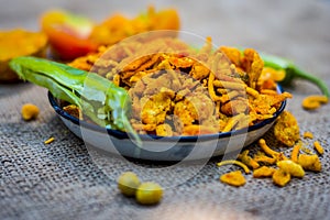 Close up Indian snack mix chevdo in a plate with green chillies. photo