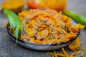 Close up Indian snack mix chevdo in a plate with green chillies. photo