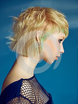 Close-up indoor portrait of lovely girl with blonde hair. Studio shot of graceful young woman with short haircut