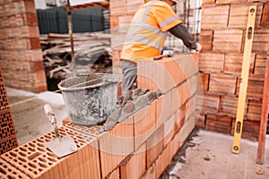 Close up of industrial bricklayer installing bricks