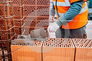 Close up of industrial bricklayer installing bricks