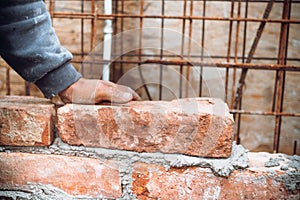 Close up of industrial bricklayer installing bricks on construction site
