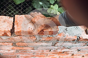 Close up of industrial bricklayer installing bricks on construction site