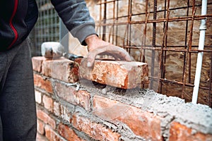 Close up of industrial bricklayer installing bricks on construction site. Construction works